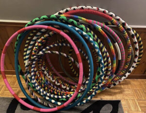 Several multi-coloured hula hoops stacked together.